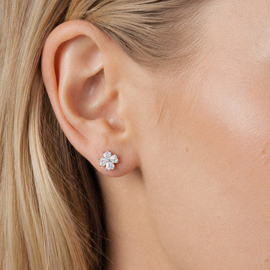 Clear four-petal stud shown on an earlobe in an existing SENLANSP catalog display; no glasses are shown.