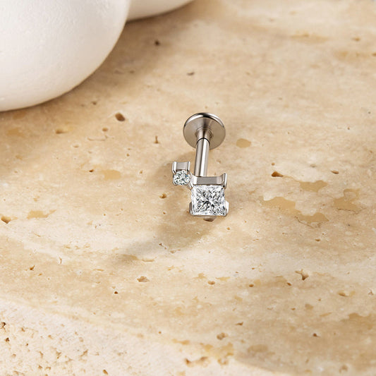 Silver-colored princess-cut flat-back stud with a round accent stone, an example design to identify in a jewelry record